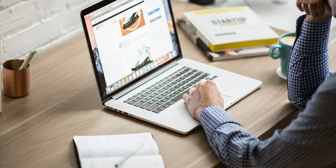 Writer working on a laptop at a wooden desk
