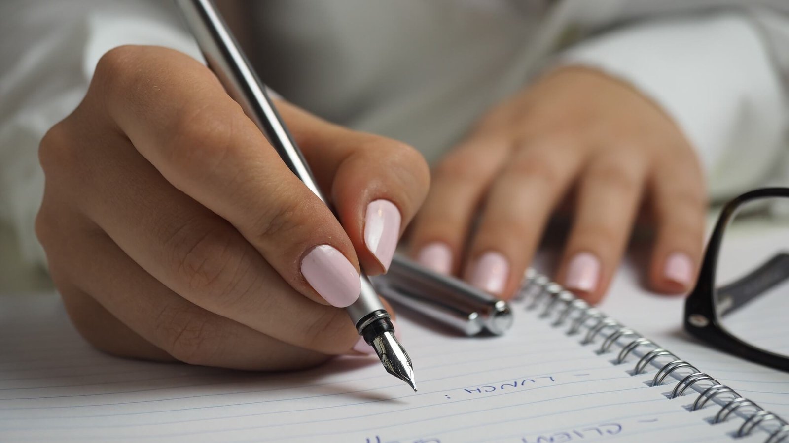 Writer drafting notes by hand in a spiral notebook