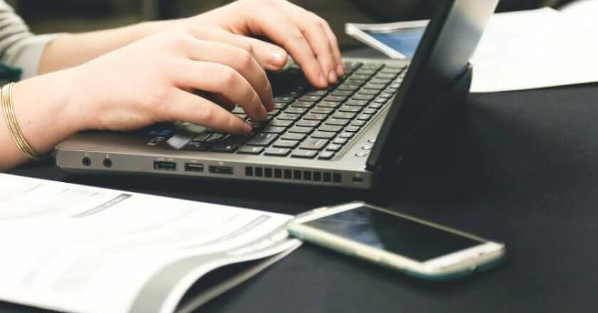 Writer typing a manuscript on a laptop